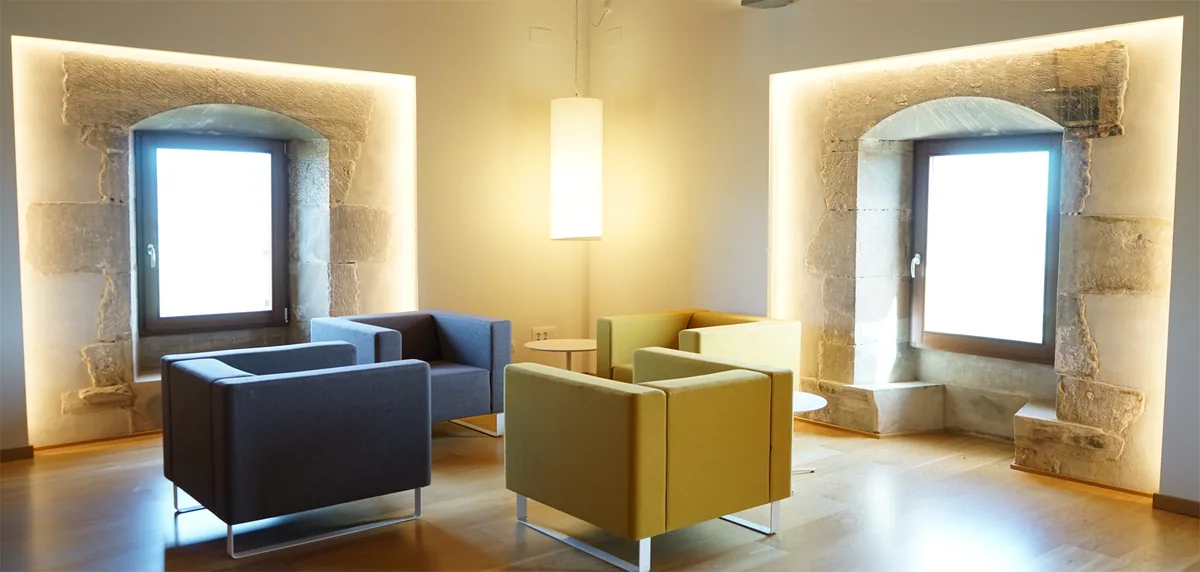 Sala d'estar de l'Hotel Santuari amb els finestrals de pedra originals